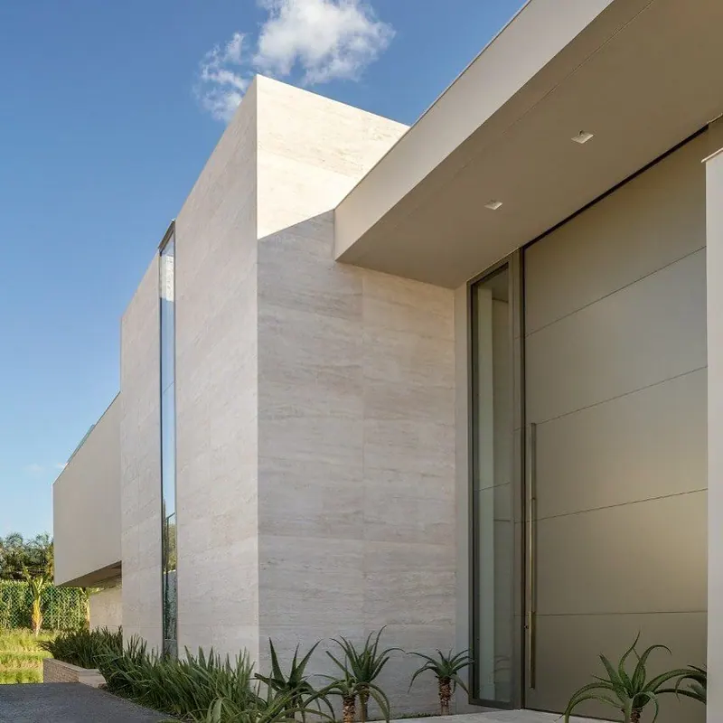 Fachada contemporânea revestida com placas claras de Travertino Romano